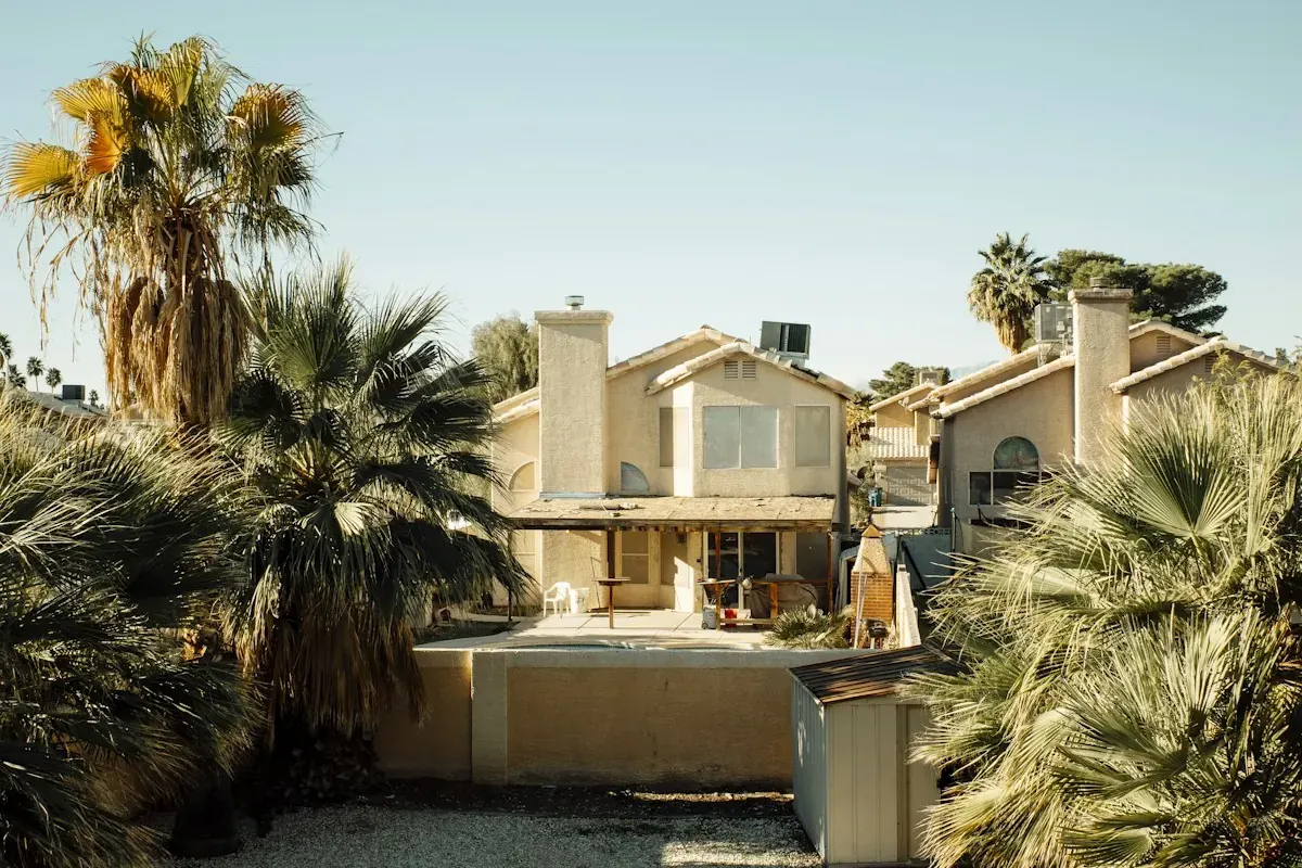 A backyard pool with palm trees in a desert neighborhood