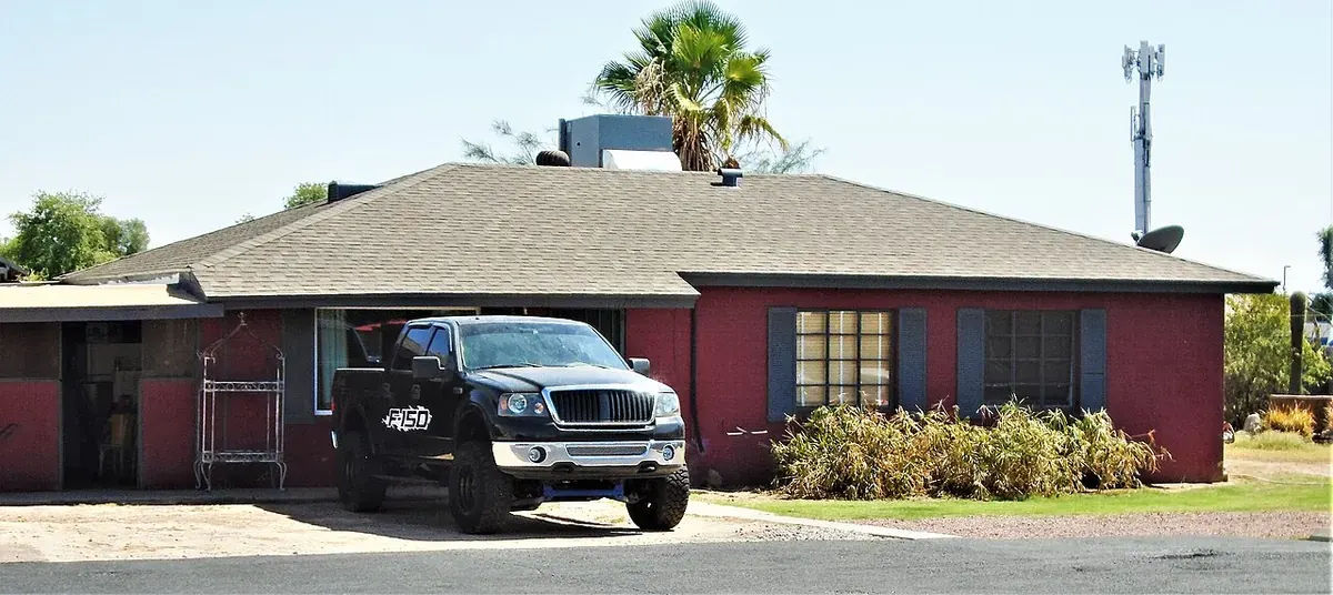 A pickup truck parked on a concrete driveway in front of a ranch home in Gilbert, Arizona