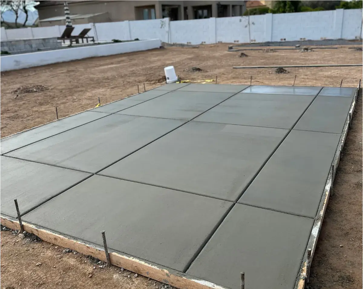 A newly poured, broom-finished concrete pad with saw-cut control joints in the Phoenix area
