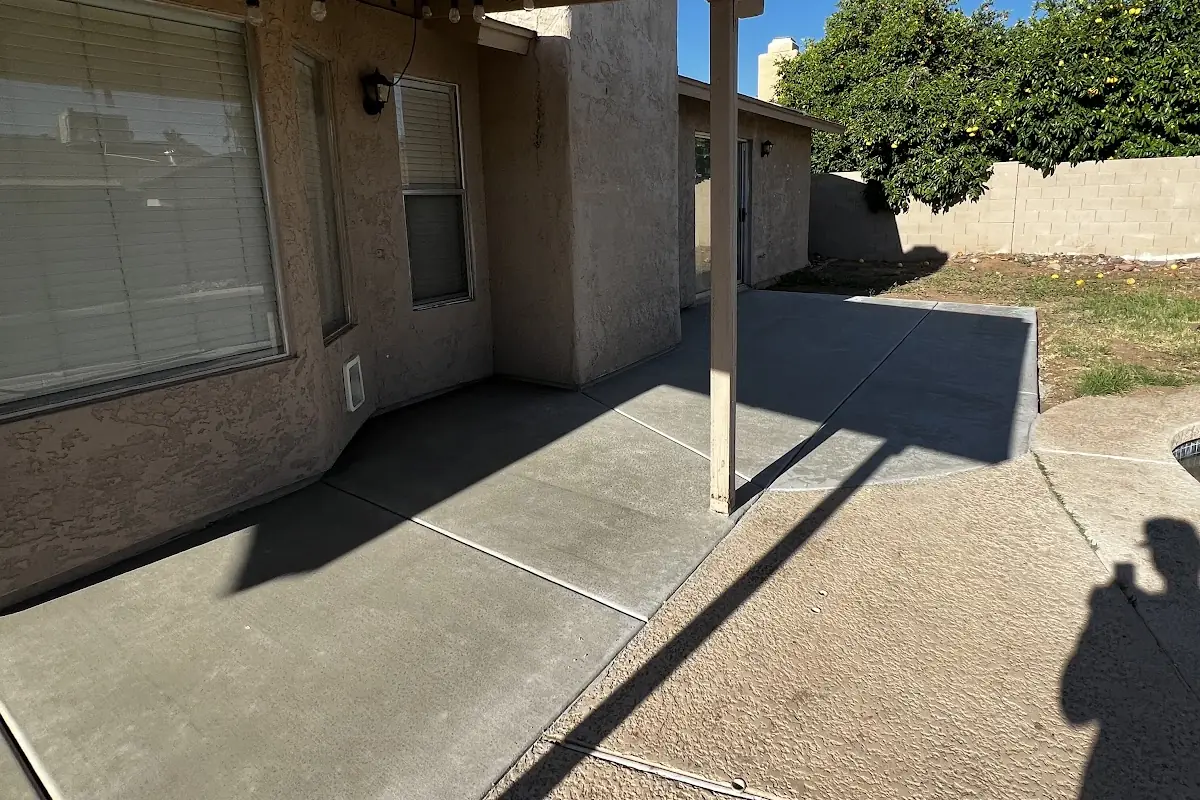 A new concrete patio extension under a covered patio, poured by our featured contractor