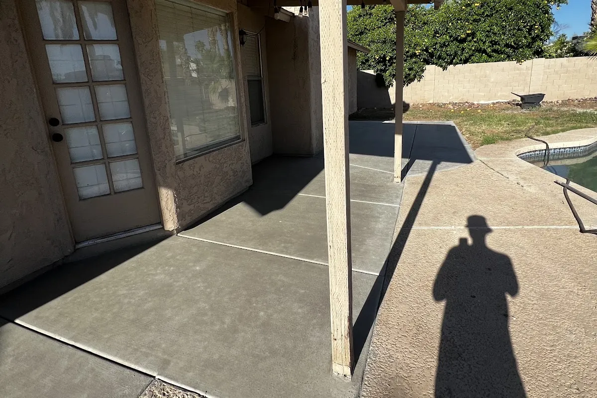 A new concrete slab beside a pool and covered patio, poured by our featured contractor