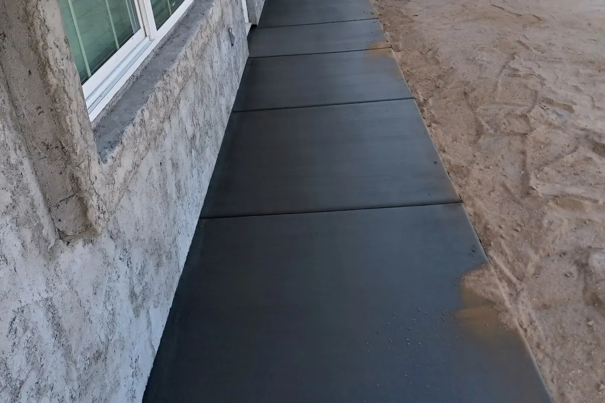 A new concrete strip along the side of a house