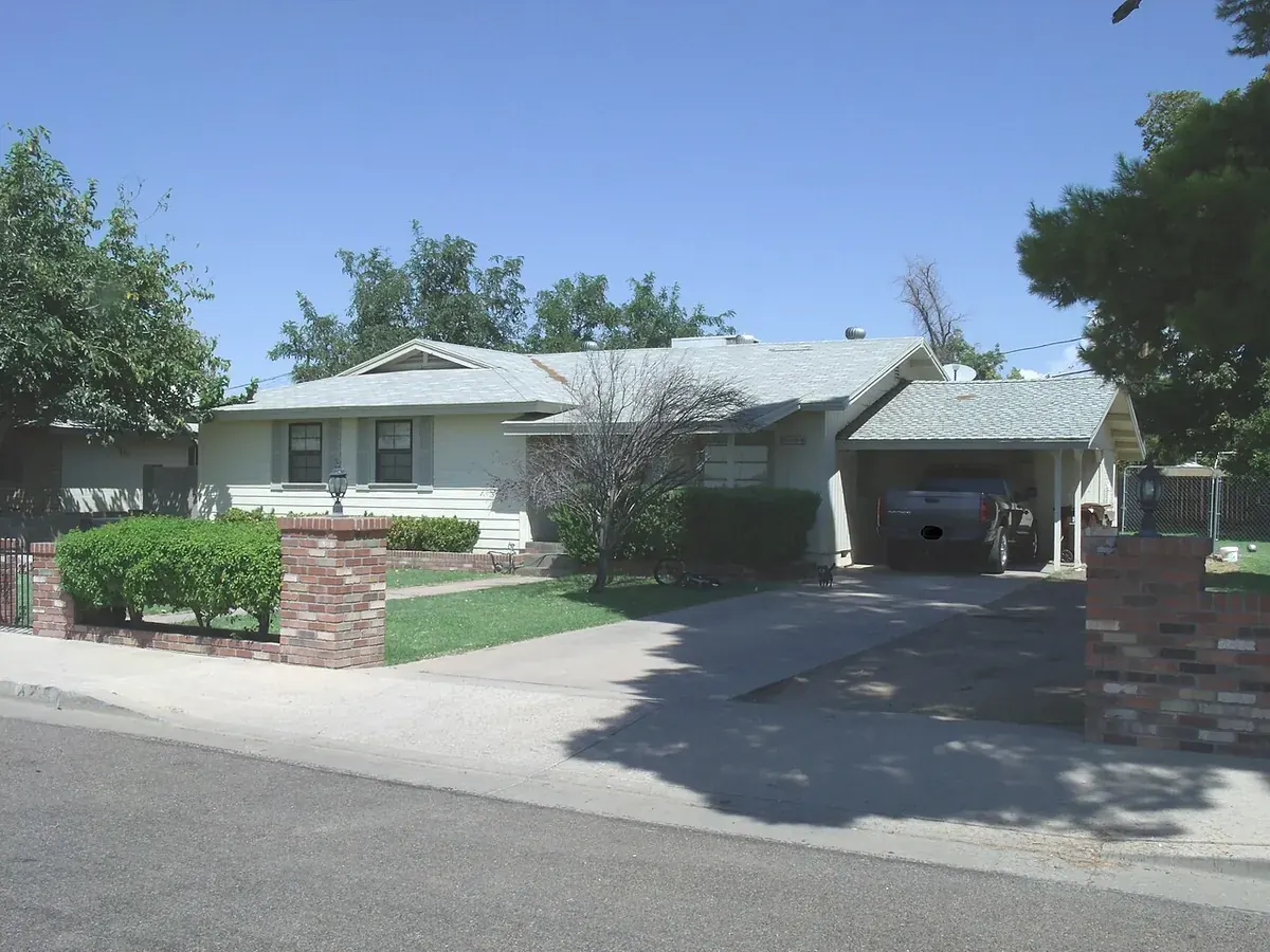 An older Valley home with a carport and a concrete drive
