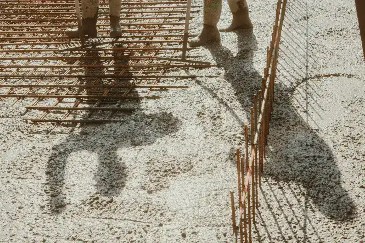 Fresh concrete flowing over steel reinforcement during a slab pour