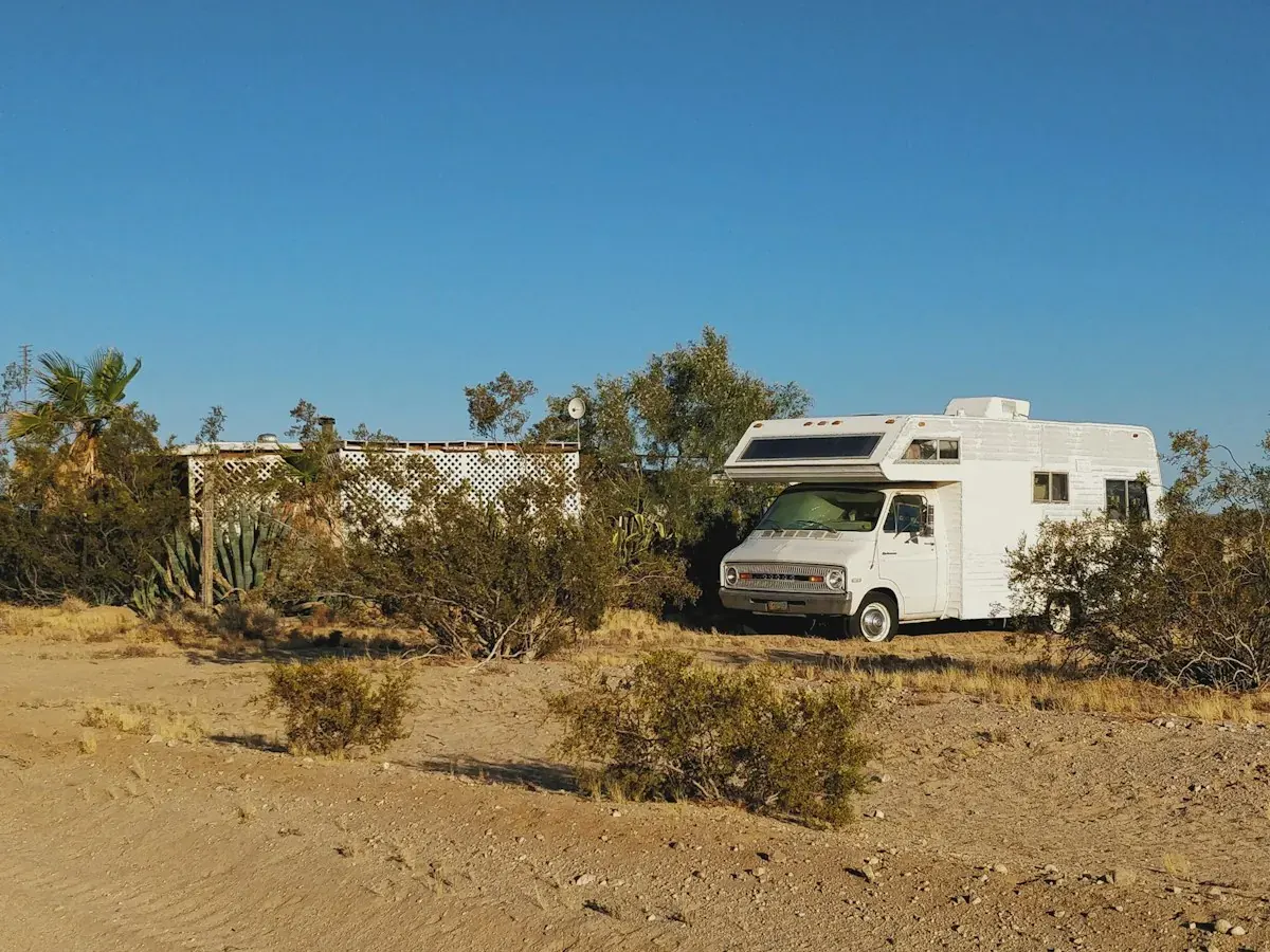 A Class C motorhome parked on a desert lot