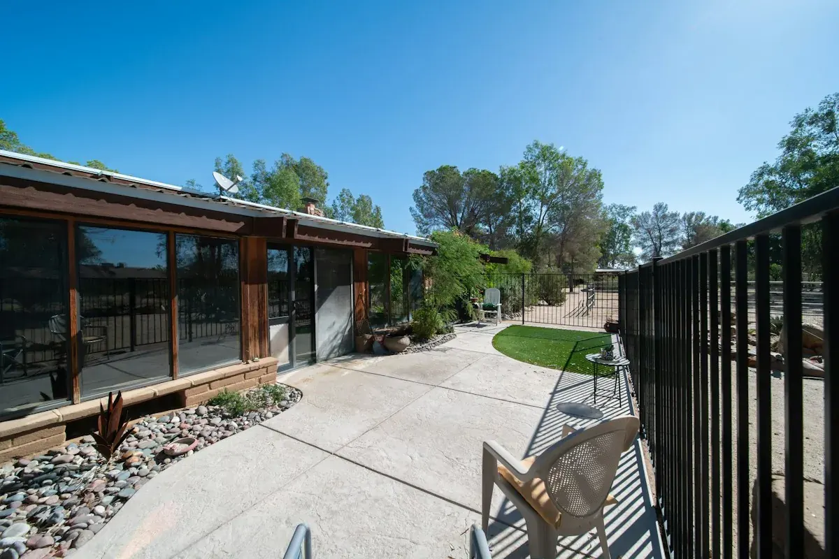 A concrete side yard and patio with desert landscaping, where condensers and equipment often sit